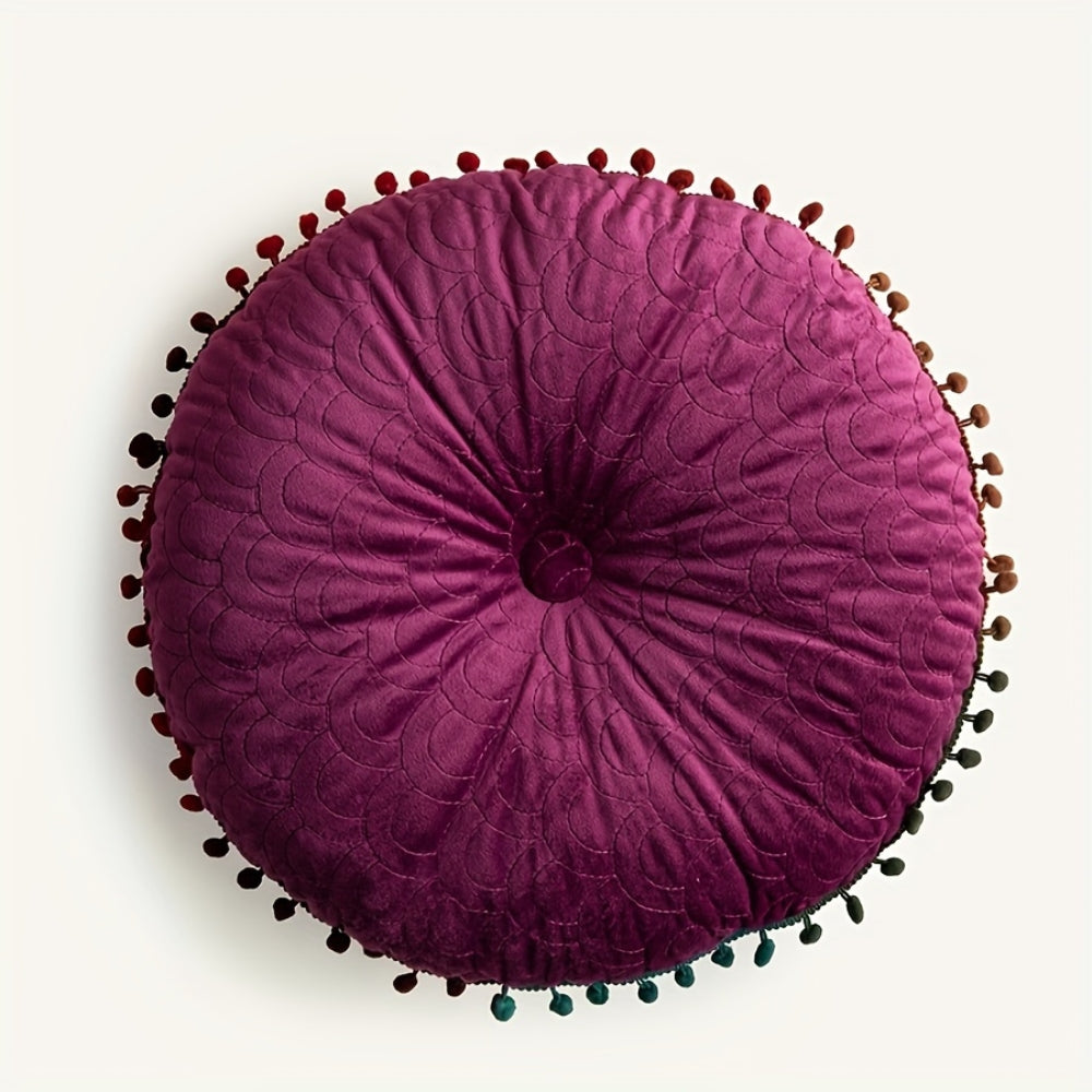 Plum round velvet cushion seen from above
