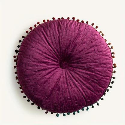 Plum round velvet cushion seen from above