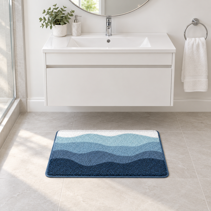 Small blue wave bath mat in front of a white bathroom vanity with a round mirror