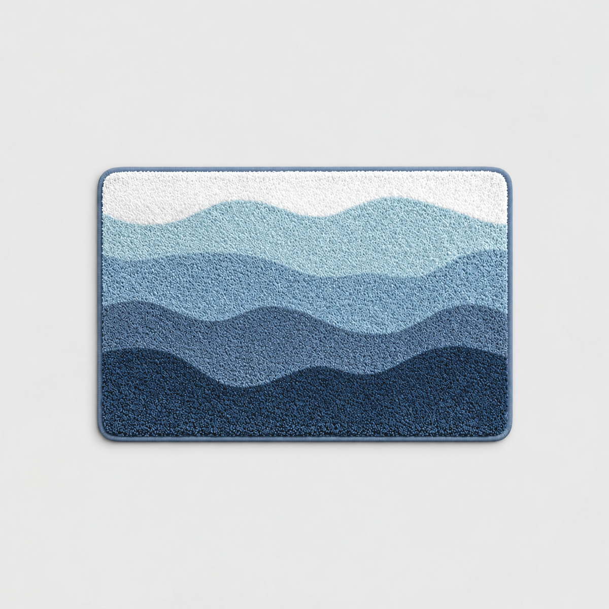 Blue wave pattern bath mat with white, sky blue and navy bands, on a light gray background