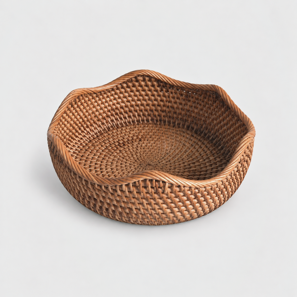 Large shallow round rattan basket with a wavy rope-wrapped rim on a light gray background