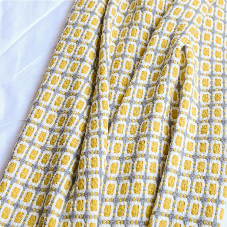 Close-up of the mustard, white and gray grid knit showing the texture of the blocks