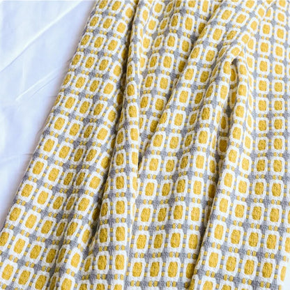 Close-up of the mustard, white and gray grid knit showing the texture of the blocks