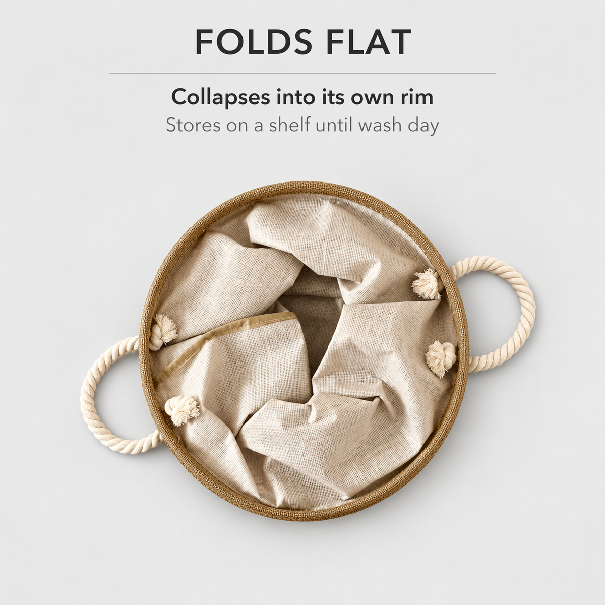 The laundry basket folded flat seen from above, its rim lying on the floor with both rope handles out to the sides, and the text Folds flat