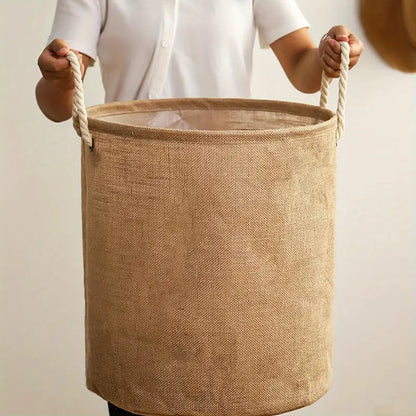 Laundry basket held up by its two twisted rope handles, showing the cream lining inside the rim