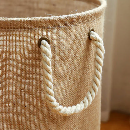 Close-up of a twisted cream rope handle threaded through dark metal eyelets on the linen weave