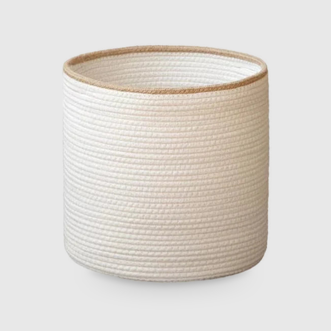 Medium white cotton rope storage basket with a beige rim, as tall as it is wide, on a light gray background