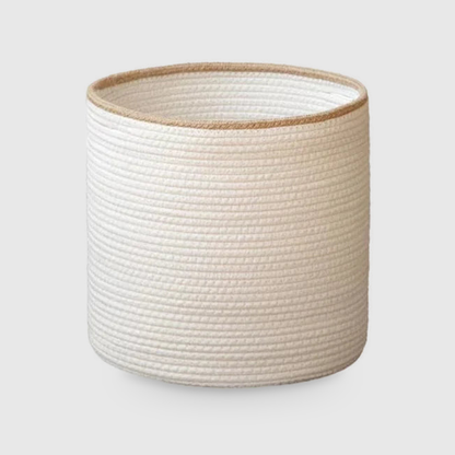 Medium white cotton rope storage basket with a beige rim, as tall as it is wide, on a light gray background