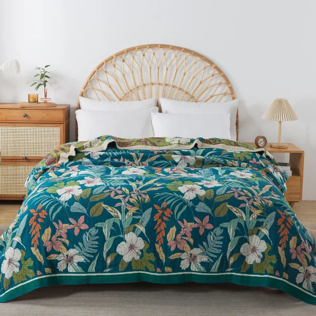 Deep teal floral cotton coverlet with white and pink flowers spread over a bed