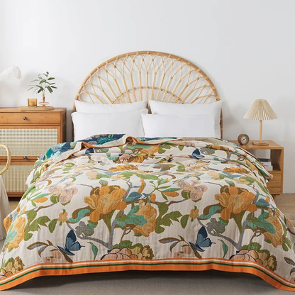 Cream cotton coverlet with golden mustard flowers and blue butterflies spread over a bed