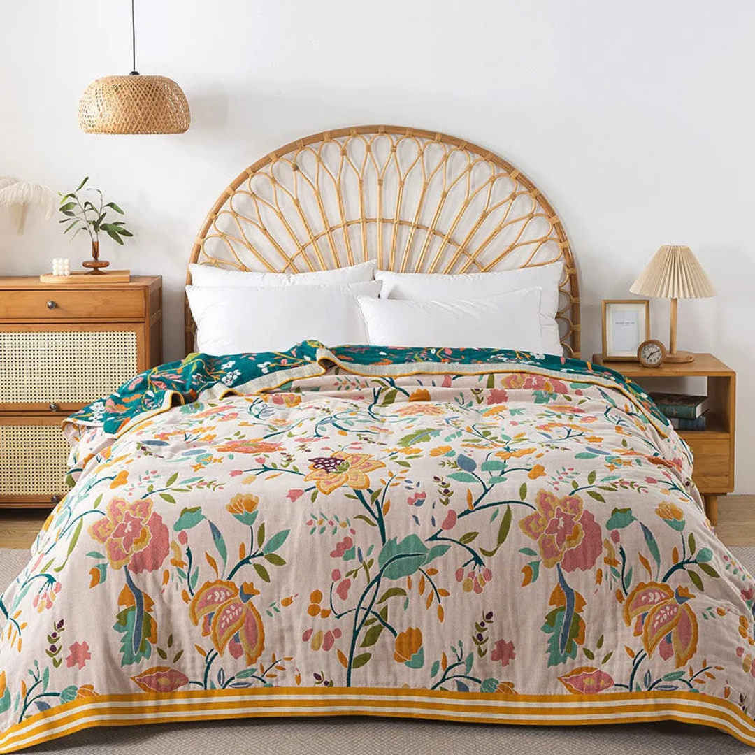 Blush floral cotton coverlet with pink and orange flowers spread over a bed