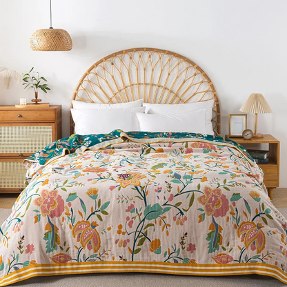 Blush floral cotton coverlet with pink and orange flowers spread over a bed