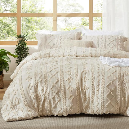 Beige tufted duvet cover set made up on a bed with two matching pillow shams in front of a window