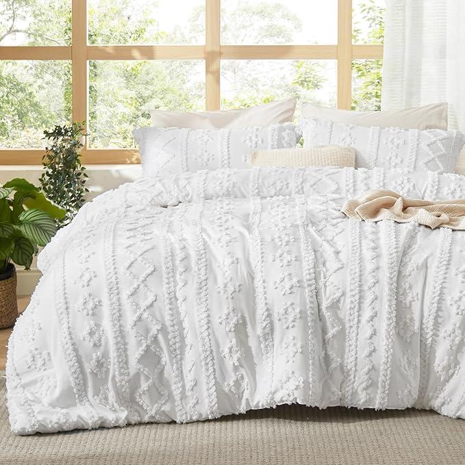 White tufted duvet cover set with geometric stripes made up on a bed by a window