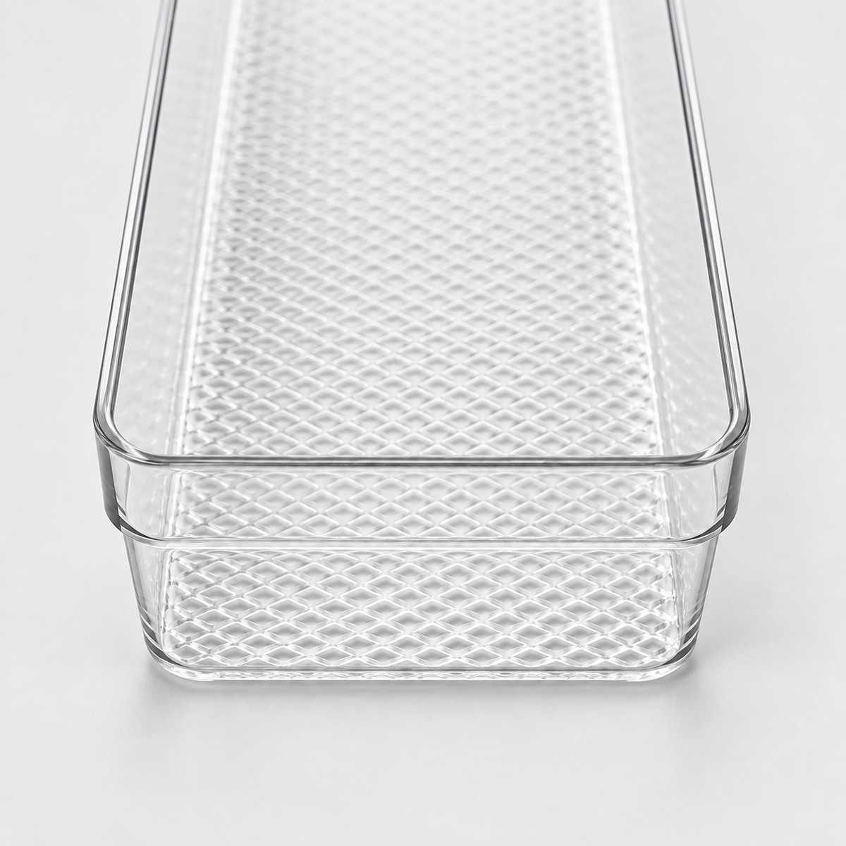 Close-up of the clear tray's rounded corner, flat rim and textured floor