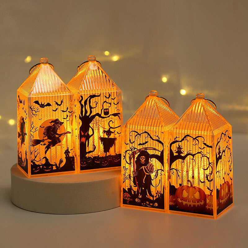 Four lit mini Halloween lanterns in witch, scarecrow, reaper and pumpkin designs, two raised on a round plinth