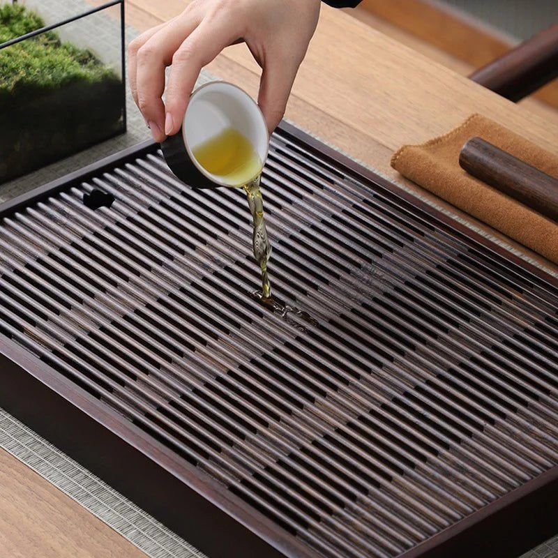 A cup of tea tipped out onto the bamboo slats, the water running straight down through the gaps.