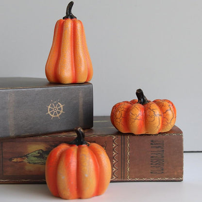 Three unlit pumpkin lights stepped on books against a plain wall