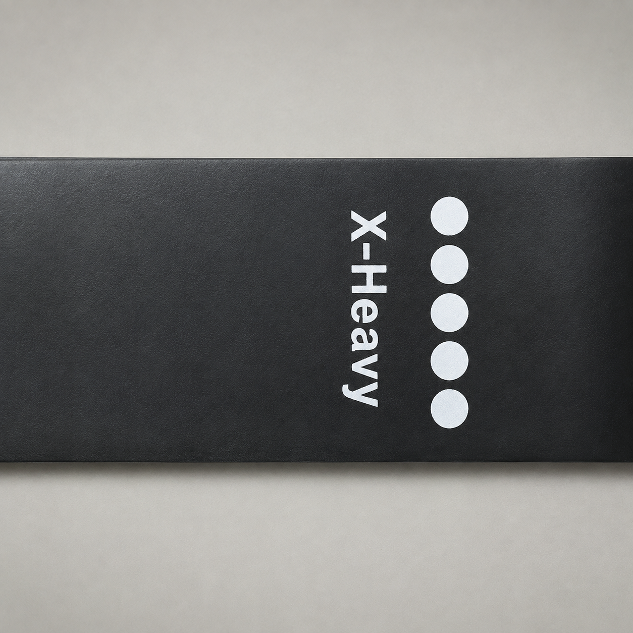 Close up of the X-Heavy marking printed across a band, with five filled circles beside the word