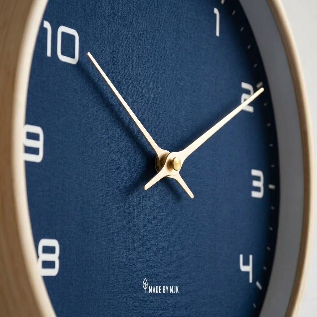 Close view of the pale gold-tone hands and center cap over the textured navy blue dial