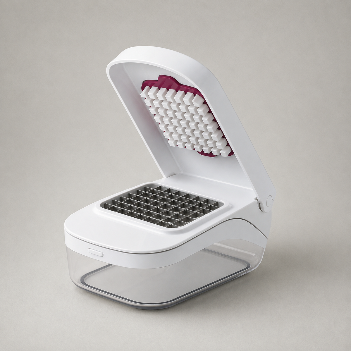 White vegetable chopper on a plain grey background with the lid open and the container empty, showing the stainless steel blade grid and the deep pink peg pad inside the lid.