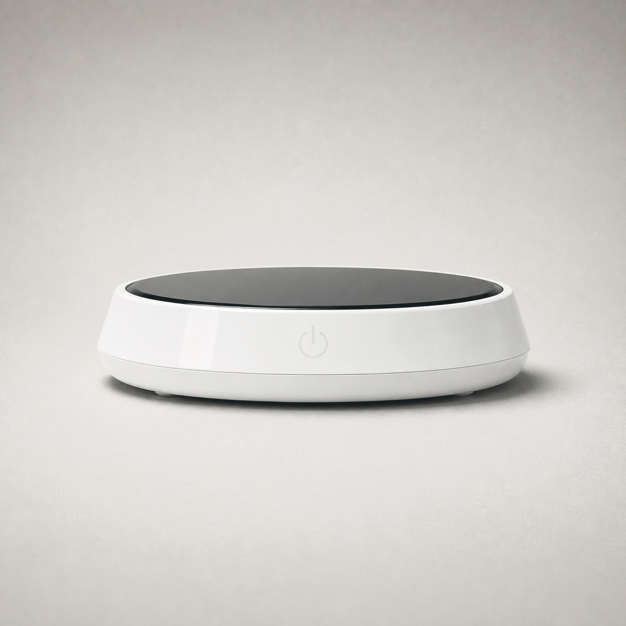 Mug warmer on plain grey, white body with a black glass top plate