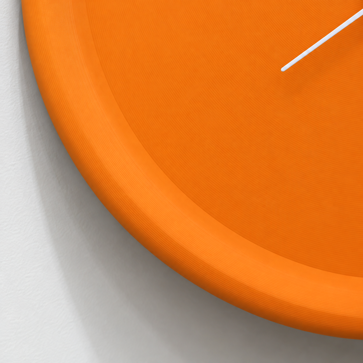 Close-up of the orange clock's raised rim and matte 3D printed surface