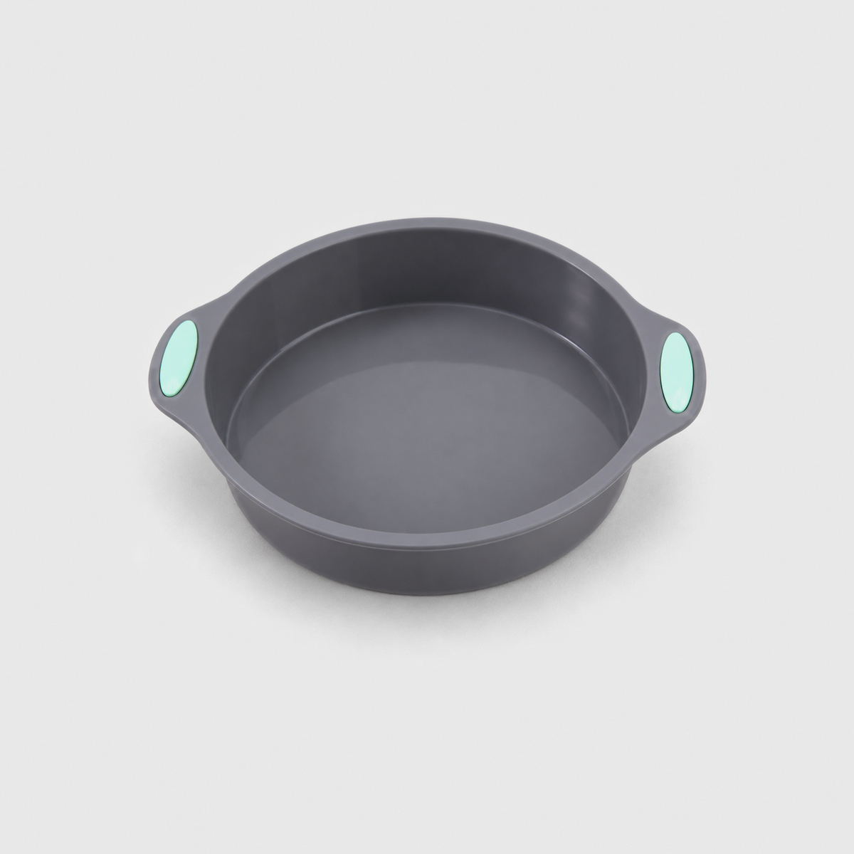Gray silicone round cake pan with two small handles and mint-green pads, on a light gray background