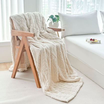 Ivory fleece blanket draped over a wooden armchair by the bed