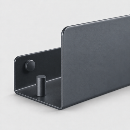 Close-up of the open end of a black aluminum shelf showing the short back plate, a screw head, the hook peg and the tall front lip
