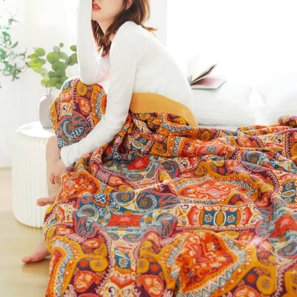 Light throw blanket over a person sitting up in bed beside a small side table