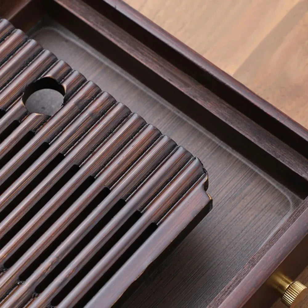 Close-up of the rounded bamboo slats and the round hole in the top, with the reservoir floor and the drain cap below.