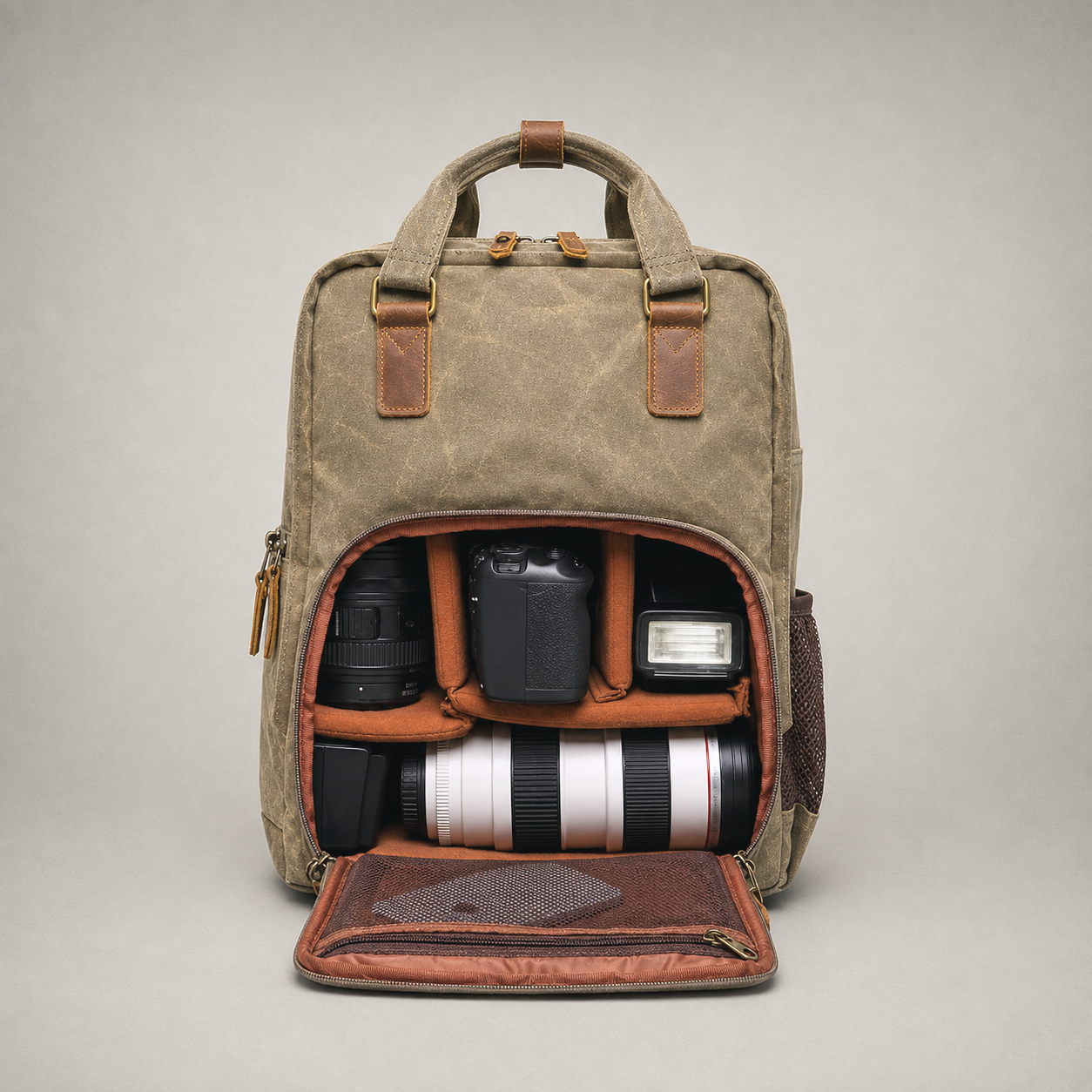 Camera backpack open on a grey studio background showing padded dividers and gear.