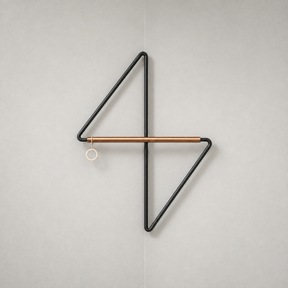 Front view of the black metal corner coat rack on a plain grey background, with the upper arm to the left, the lower arm to the right, the crossbar across the middle and a ring at its left end.