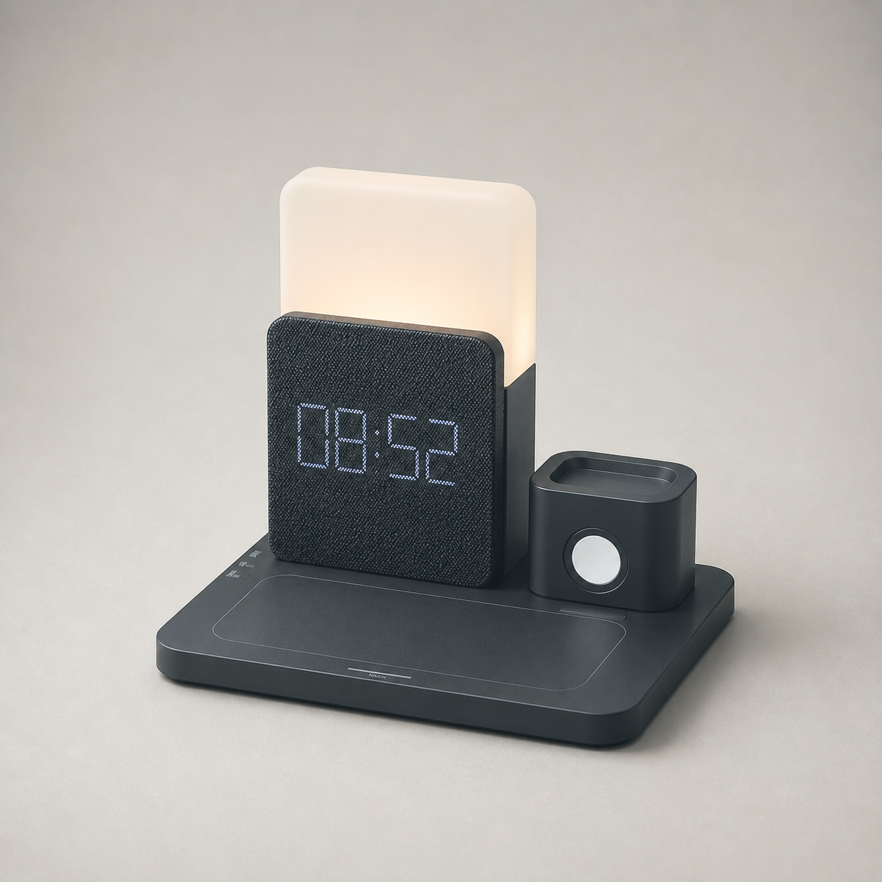 Black charging station on plain grey, lamp lit, fabric clock face, phone pad and watch dock