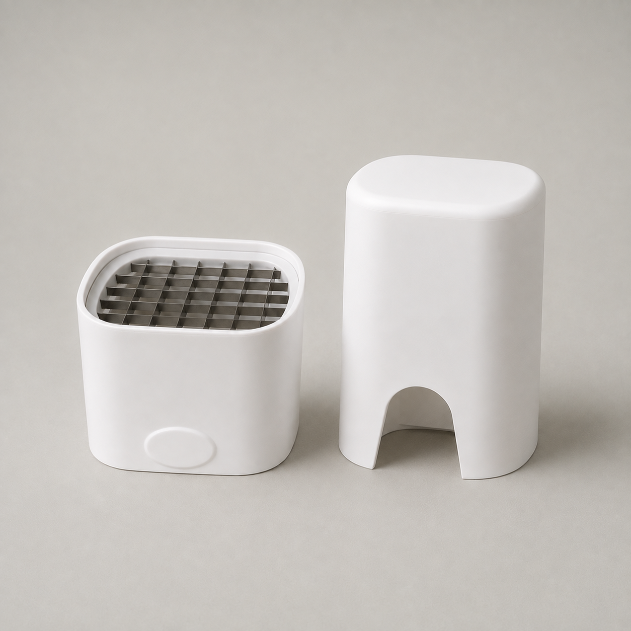 Studio photograph of the two piece manual french fry cutter, base with blade grid beside the press