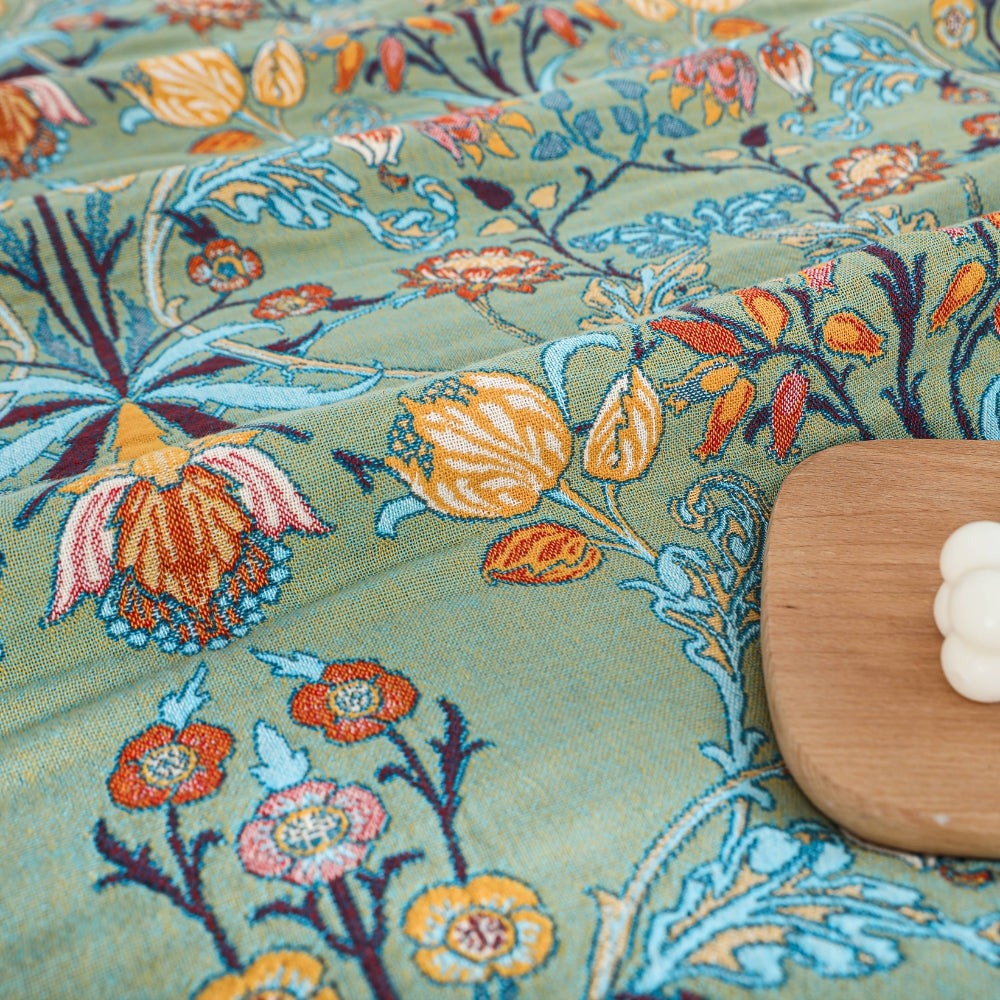 Close-up of woven tulips and small flowers on the sage green ground
