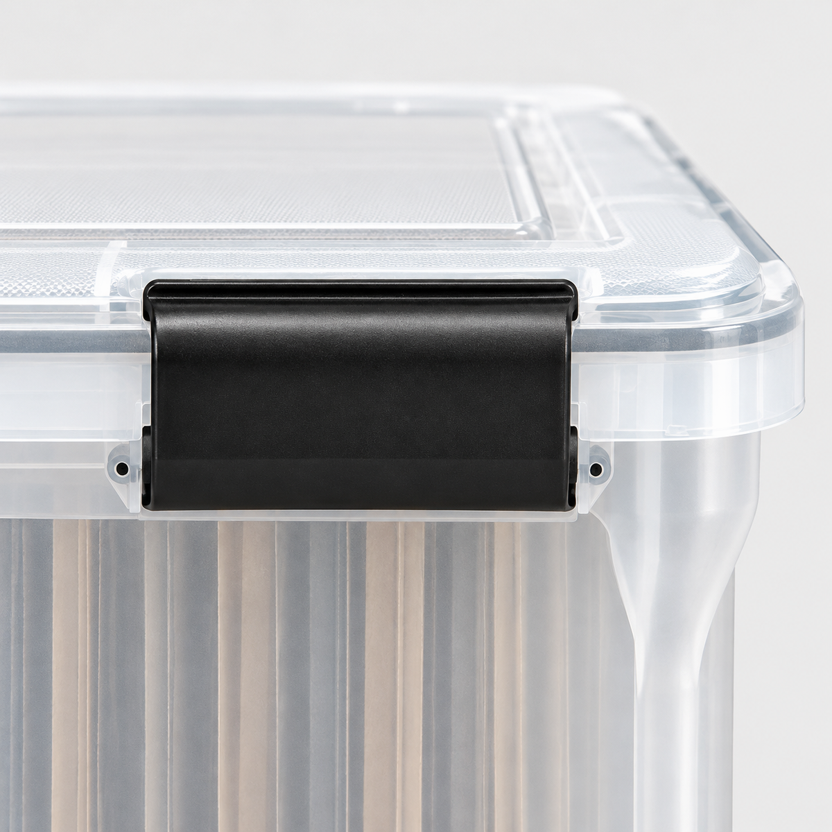 Close-up of a black latch clipped over the clear lid of the file box
