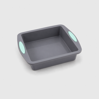 Gray silicone square cake pan with a handle tab and mint-green pad on two sides, on a light gray background
