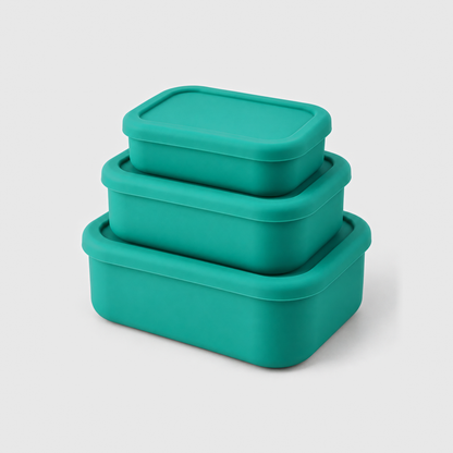 Three green silicone food storage containers in small, medium and large, stacked with their lids on