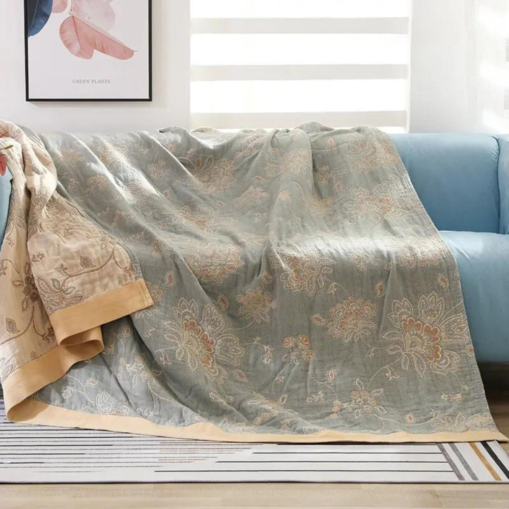 Sage floral jacquard throw blanket over a sofa, warm tan flowers woven on a soft sage face