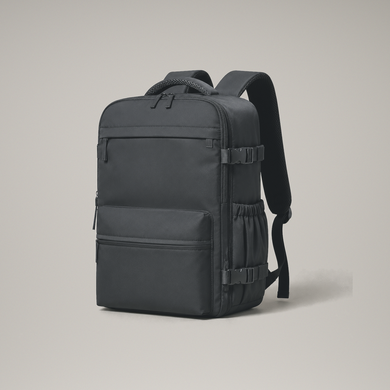 Black laptop backpack front three quarter view on a plain warm grey studio background