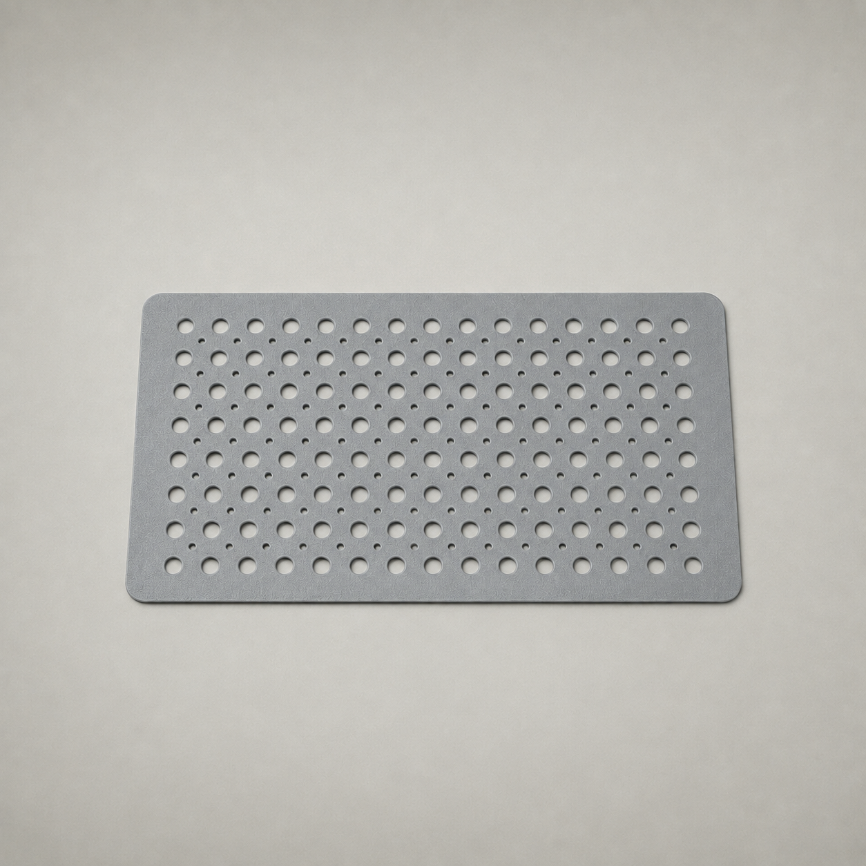 Gray non slip shower mat photographed whole on a plain grey studio background