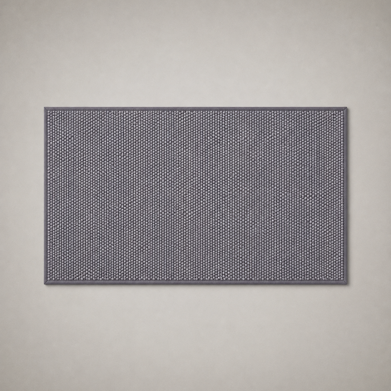 Gray woven kitchen rug photographed flat from above on a grey studio background