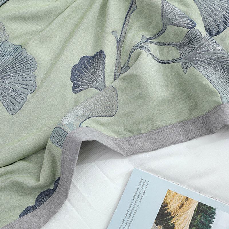 Close-up of slate gray ginkgo leaves woven into the sage green face, with the gray border at the edge