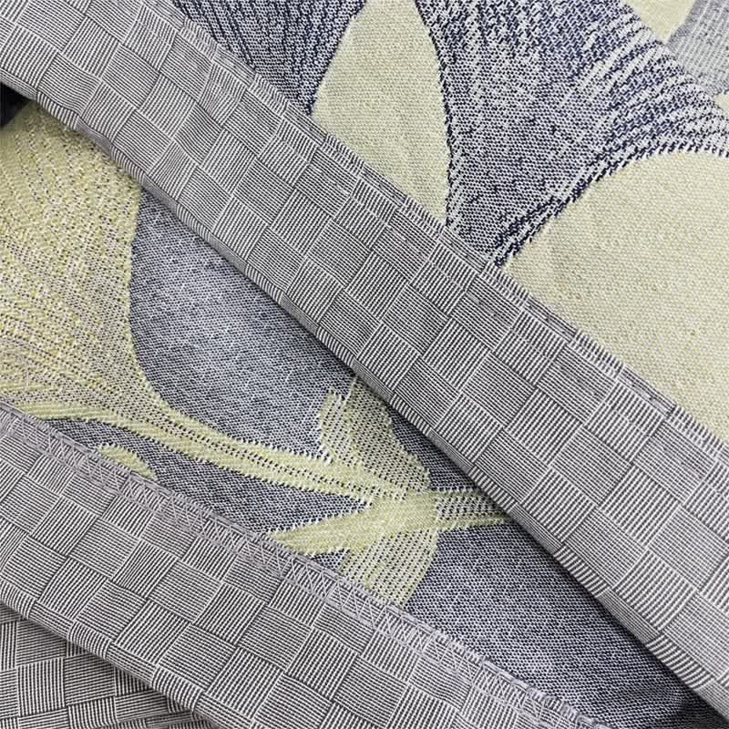 Close-up of the gray checked border and zigzag stitched edge, with the face and reverse of the quilt between