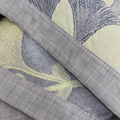 Close-up of the gray checked border and zigzag stitched edge, with the face and reverse of the quilt between
