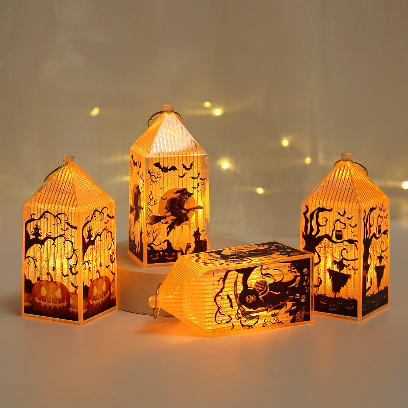 Four lit mini Halloween lanterns around a plinth, one lying on its side to show the ribbed roof and ring