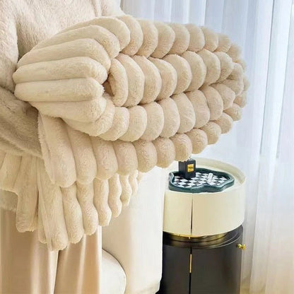 Cream faux rabbit fur throw rolled up in someone's arms, its pleats forming plump round rolls