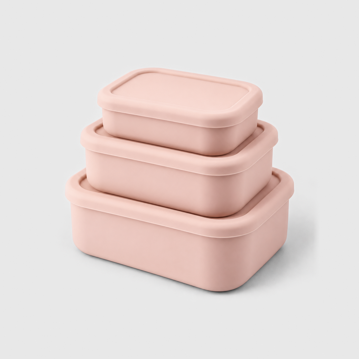 Three pink silicone food storage containers in small, medium and large, stacked with their lids on